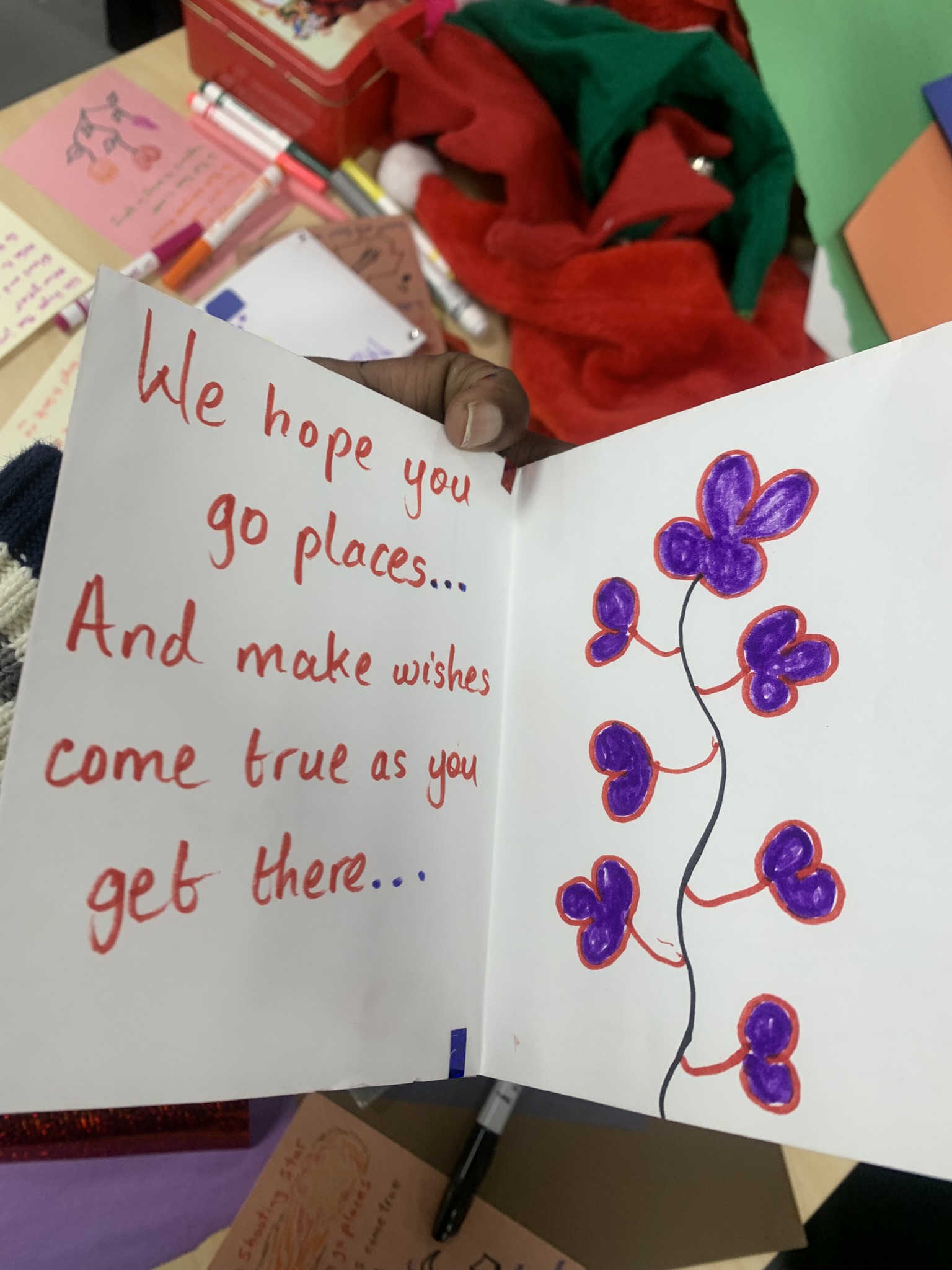 Card with red text and purple butterflies reading 'We hope you go places... And make wishes come true as you get there'